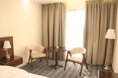 a hotel room with a bed and two chairs and a table at North paradise hotel in Irbid