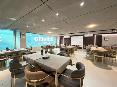 a restaurant with tables and chairs and a large screen at North paradise hotel in Irbid
