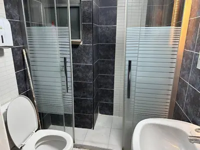 a bathroom with a shower and a toilet and a sink at استوديو مفروش لشخصين الجاردنز 320 in Amman