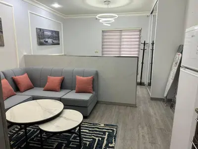 a living room with a couch and two tables at استوديو مفروش لشخصين الجاردنز 320 in Amman