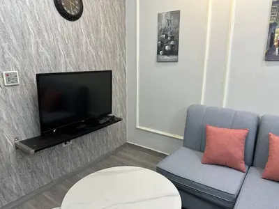 a living room with a couch and a flat screen tv at استوديو مفروش لشخصين الجاردنز 320 in Amman