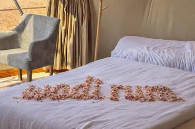 a word made out ofeddy bears on a bed with a chair at Rum Overnight luxury& jeep in Wadi Rum