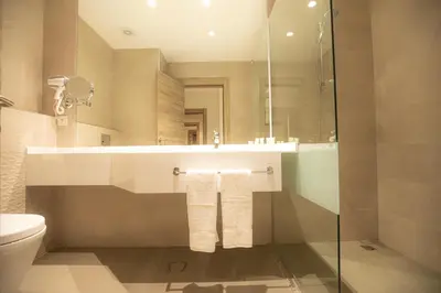 a bathroom with a sink and a toilet and a mirror at Golden Tulip Amman in Amman