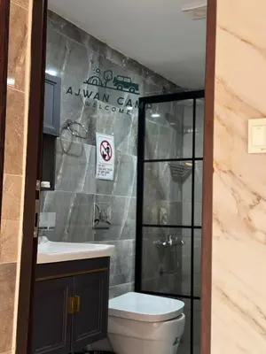 a bathroom with a toilet and a sign on the wall at WADI RUM AJWAN lUXURY CAMP in Wadi Rum