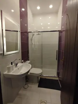 a bathroom with a toilet and a sink and a shower at Cozy Apt in amman with a view in Amman