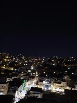a view of a city at night with lights at Cozy Apt in amman with a view in Amman