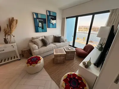 a living room with a couch and a large window at Chic One-Bedroom with Sea View in Aqaba