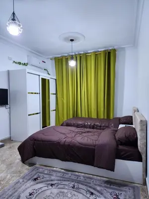 a bedroom with a bed with a green curtain at Salo StudioS in Amman