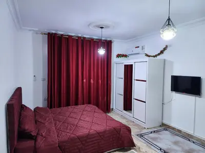 a bedroom with a bed and a red curtain at Salo StudioS in Amman