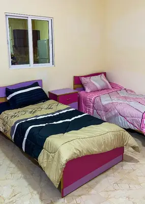 a bedroom with two beds and a window at روابي عجلون منزل in Ajloun