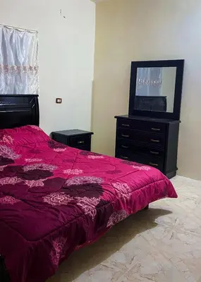 a bedroom with a purple bed and a television at روابي عجلون منزل in Ajloun