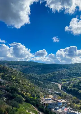 a view of a valley with a blue sky and clouds at روابي عجلون منزل in Ajloun