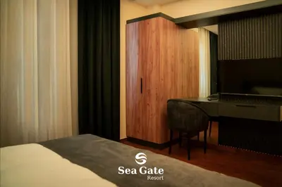 a bedroom with a bed and a desk and a piano at Sea Gate Resort in Sowayma