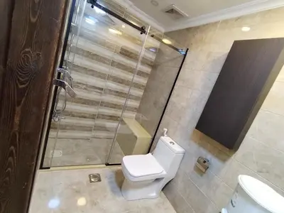 a bathroom with a toilet and a glass shower at شقه في اربد apartment in irbid in Irbid