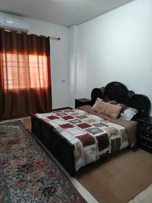 a bedroom with a large bed and a window at شقة ام نوارة الحديثة الفارهة spacious economic flat in Amman