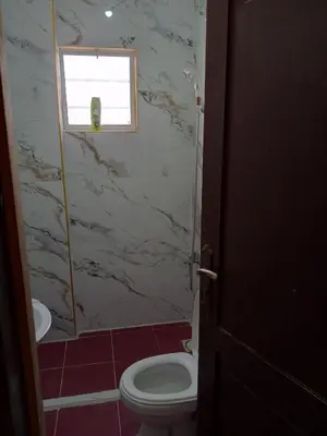 a bathroom with a toilet and a window at شقة ام نوارة الحديثة الفارهة spacious economic flat in Amman