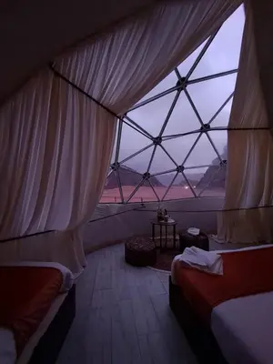a room with two beds and a large window at Aladdin Camp in Disah