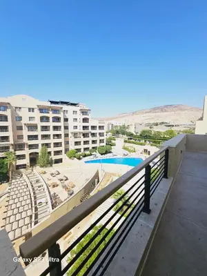 a balcony with a view of a pool and buildings at B36 Loft Apartment Samarah Resort in Sowayma
