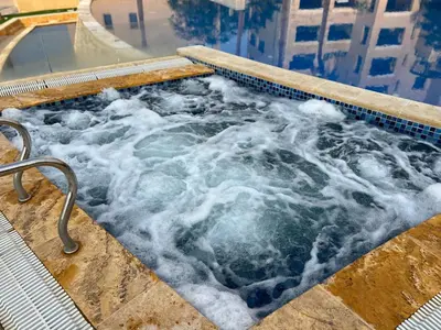 a jacuzzi tub with water in it at B35 Samarah Resort LOFT apartment in Sowayma