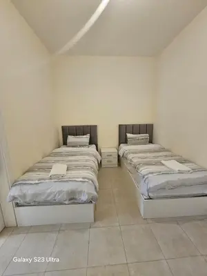two twin beds in a room with at B35 Samarah Resort LOFT apartment in Sowayma