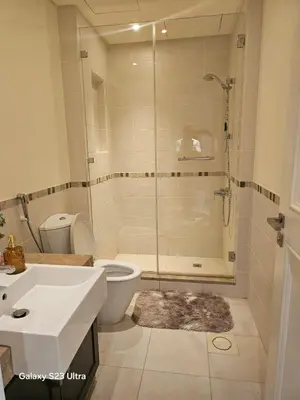 a bathroom with a shower and a toilet and a sink at B35 Samarah Resort LOFT apartment in Sowayma