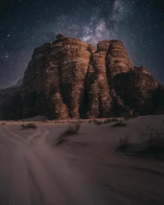 a rock formation in the desert under a starry sky at Rum Leno Luxure camp in Wadi Rum
