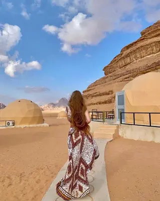 a young girl in a dress looking at the desert at Rum Leno Luxure camp in Wadi Rum