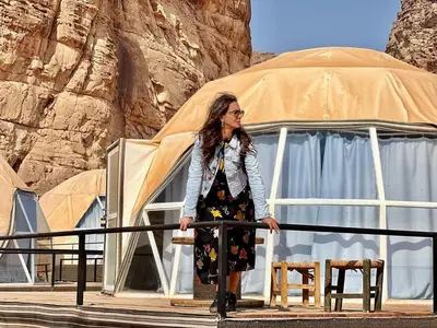 a woman standing in front of a tent at Rum Leno Luxure camp in Wadi Rum