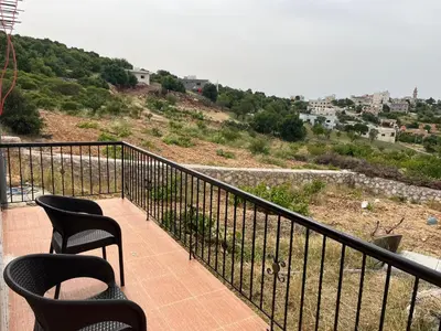 a balcony with chairs and a view of a city at منزل مستقل لقضاء اجمل الاوقات بجبال عجلون in Ajloun