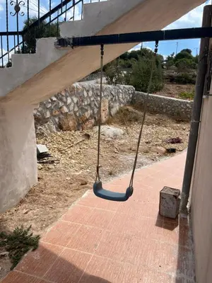 a swing hanging from a porch with a staircase at منزل مستقل لقضاء اجمل الاوقات بجبال عجلون in Ajloun