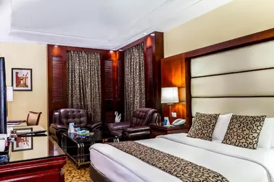 a hotel room with a bed and a living room at Grand Days Hotel & Suites Amman in Umm Uthainah