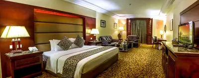 a hotel room with a bed and a television at Grand Days Hotel & Suites Amman in Umm Uthainah