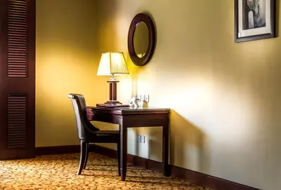 a desk with a lamp and a chair in a room at Grand Days Hotel & Suites Amman in Umm Uthainah