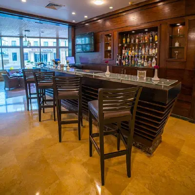 a bar in a restaurant with wooden walls and chairs at Grand Days Hotel & Suites Amman in Umm Uthainah