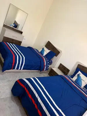 a bedroom with two beds and a mirror at Cozy Flat, Amman Airport in Amman