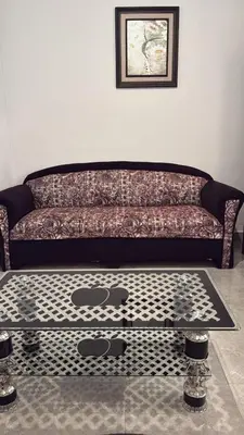 a living room with a couch and a table at Cozy Flat, Amman Airport in Amman