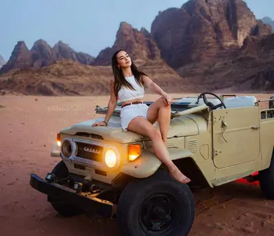 a woman sitting on top of a jeep in the desert at RUM MARTiN BUBBLES lUXURY CAMP in Wadi Rum
