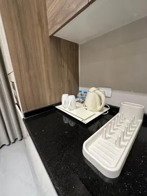 a kitchen with a white appliance on a black counter top at Chic Apartments For Rent ave2-1 in Amman