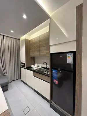 a kitchen with a black refrigerator and a sink at Chic Apartments For Rent ave2-1 in Amman