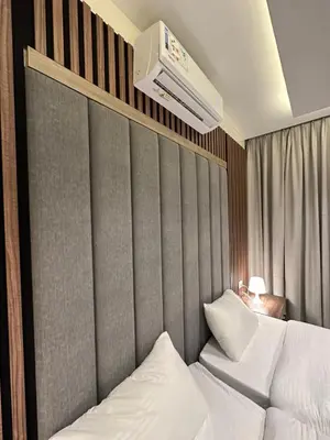 a bedroom with a bed and a wall with a heater at Chic Apartments For Rent ave2-2 in Amman