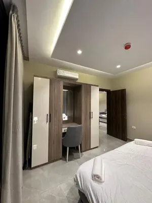 a bedroom with a bed and a desk with a chair at Chic Apartments For Rent ave2-2 in Amman