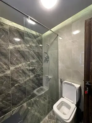 a bathroom with a toilet and a glass shower at Chic Apartments For Rent ave2-2 in Amman