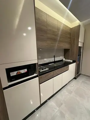 a kitchen with white cabinets and a stove top oven at Chic Apartments For Rent ave2-6 in Amman