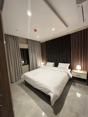 a bedroom with a large white bed with two lamps at Chic Apartments For Rent ave2-8 in Amman