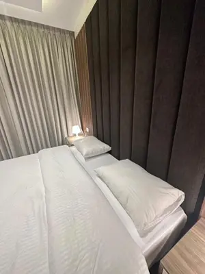 a bedroom with a bed with white sheets and pillows at Chic Apartments For Rent ave2-9 in Amman