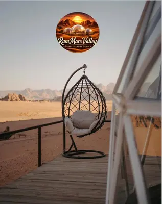 a chair sitting on a dock on the beach at RUM MARS VALLEY BUBBLE lUXURY CAMP in Wadi Rum