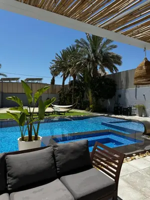 a patio with a couch and a swimming pool at Maui Villa by Seahorse in Al Rama
