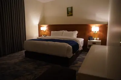 a hotel room with a large bed with two lamps at فندق أوتار ذهب in Ma‘ān