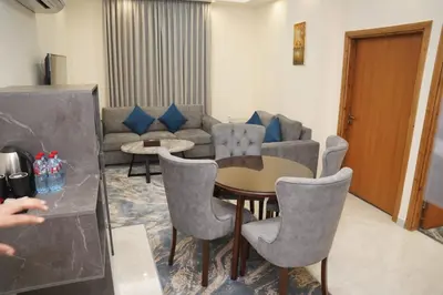 a living room with a couch and a table and chairs at فندق أوتار ذهب in Ma‘ān