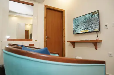 a living room with a tv on a wall at فندق أوتار ذهب in Ma‘ān